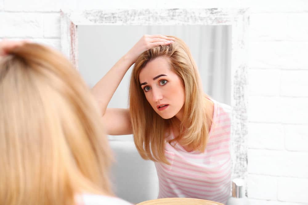 Mujer al espejo mirándose el cabello
